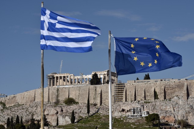 The Greek and EU flags flutter in front of the ancient Acropolis hill in Athens on January 15, 2015. Before snap elections were unexpectedly called in Greece on January 25, the troubled country was expected to finally limp out of recession after six painful years in the red. Now, with a clear electoral result far from certain, Greece's long-suffering business community fears that any chance of a tentative recovery will be delayed -- if not killed off outright -- by a damaging political stalemate.  AFP PHOTO / LOUISA GOULIAMAKI        (Photo credit should read LOUISA GOULIAMAKI/AFP/Getty Images)