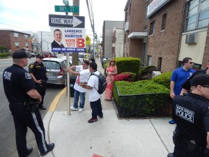 Police direct Wainstein supporters to remove a poster from a sign post.