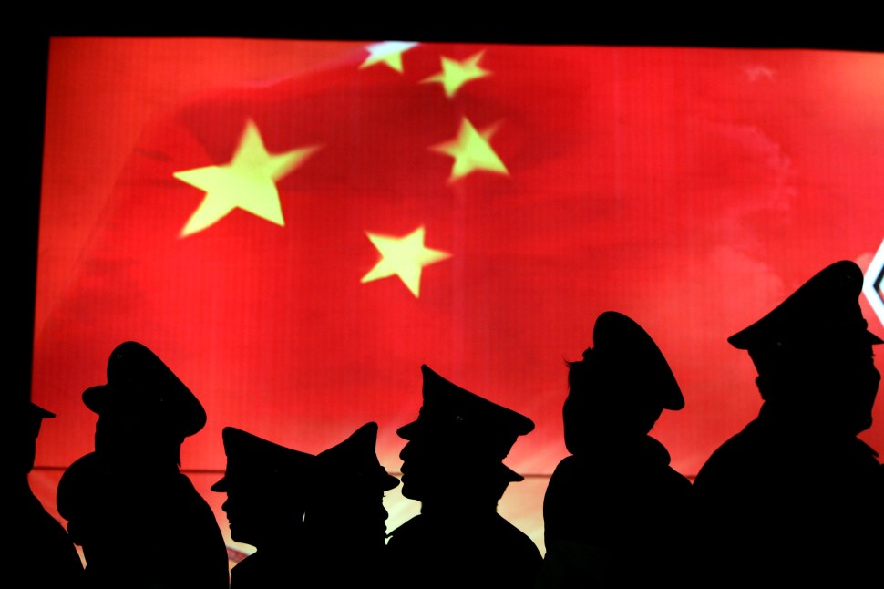 BEIJING, CHINA - MARCH 1: (CHINA OUT) Security guard walk past the Chinese national flag at the Military Museum of Chinese People's Revolution on March 1, 2008 in Beijing, China. From March 1, the Military Museum of Chinese People's Revolution becomes the first national level museum which opens to the public for free in Beijing. (Photo by China Photos/Getty Images)