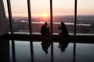 NEW YORK, NY - MAY 29:  People view the sunrise at the newly built One World Observatory at One World Trade Center on the day it opens to the public on May 29, 2015 in New York City. The observation deck sits atop the 104-story skyscraper at the former site of the Twin Towers and is expected to become one of Manhattan's top tourist attractions.  (Photo by Spencer Platt/Getty Images)