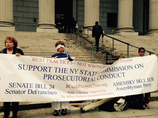 Protesters, one dressed as Lady Justice, push for a State Commission on Prosecutorial Conduct (Photo: Will Bredderman).