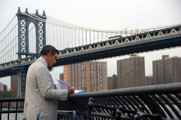 Poet Richard Blanco scribbles some notes before reading Walt Whitman's "Crossing Brooklyn Ferry" at the 20th Anniversary of Poets House's annual walk across The Brooklyn Bridge. (Photo: Justin Joffe/Observer)