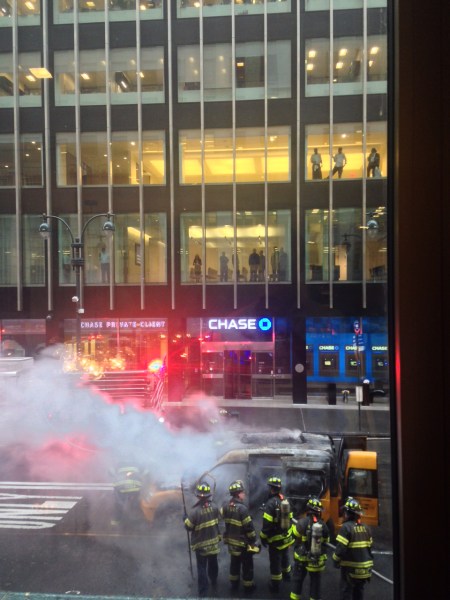Chase employees look on as FDNY puts out a fire that consumed a New York taxicab. 