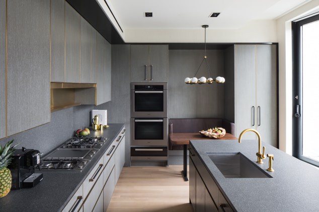 Each kitchen is custom designed by Mr. Juul-Hansen, featuring quarter-sawn white oak millwork, cerused, limed, and stained gray with brass trim.