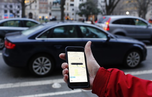 An UBER application is shown as cars drive by in Washington, DC on March 25, 2015. Uber said it was ramping up safety in response to rape allegations against a driver in India and growing concerns about background checks for operators of the popular ride-sharing service. In other cities where Uber operates, critics had complained that a lack of licensing and background checks of drivers could imperil those who use the service. AFP PHOTO/ ANDREW CABALLERO-REYNOLDS        (Photo credit should read Andrew Caballero-Reynolds/AFP/Getty Images)