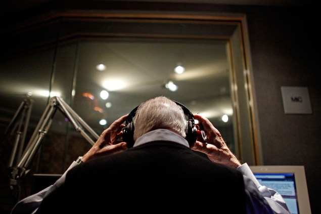 Long-time radio reporter Carl Kasell puts on headphones before delivering newscast (Photo: Chip Somodevilla/Getty Images).