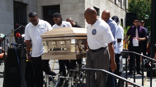 Brooklyn Borough President Eric Adams carries a casket outside Borough Hall today. (Photo: Ross Barkan/New York Observer.)