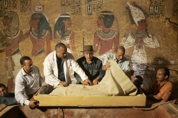 Egypt's antiquities chief Zahi Hawass (C) supervises the removal of the linen-wrapped mummy of King Tutankhamun from his stone sarcophagus in his underground tomb in the famed Valley of the Kings in Luxor, 04 November 2007. The true face of ancient Egypt's boy king Tutankhamun was revealed today to the public for the first time since he died in mysterious circumstances more than 3,000 years ago. The pharaoh's mummy was moved from its ornate sarcophagus in the tomb where its 1922 discovery caused an international sensation to a nearby climate-controlled case where experts say it will be better preserved. AFP PHOTO/POOL/Ben CURTIS (Photo credit should read BEN CURTIS/AFP/Getty Images)