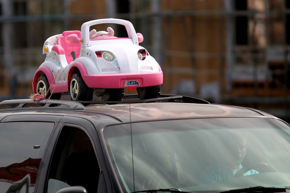 LOS ANGELES, CA - APRIL 25: A downtown driver carries a child's toy car on his roof on April 25, 2013 in Los Angeles, California. The nation's second largest city, Los Angeles, has again been ranked the worst in the nation for ozone pollution and fourth for particulates by the American Lung Association in it's annual air quality report card. Ozone is a component of smog that forms when sunlight reacts with hydrocarbon and nitrous oxide emissions. Particulates pollution includes substances like dust and soot. (Photo by David McNew/Getty Images)