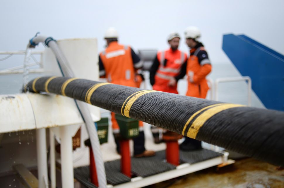 Employees of ERDF (Electricity Network Distribution France) and Louis Dreyfus company install an electric submarine cable and optical fiber between Quiberon and Belle-Ile-en-mer, western France, on March 11, 2015. The underwatered power line of 15km is installed by ERDF to connect the Brittany island of Belle-Ile-en-mer inhabited by 5000 people. AFP PHOTO / JEAN-SEBASTIEN EVRARD (Photo credit should read JEAN-SEBASTIEN EVRARD/AFP/Getty Images)