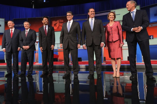 Republican presidential candidates Jim Gilmore, Sen. Lindsey Graham, Louisiana Gov. Bobby Jindal, Rick Perry, Rick Santorum, Carly Fiorina and George Pataki pose for a photograph at the beginning of a presidential forum hosted by FOX News and Facebook at the Quicken Loans Arena August 6, 2015 in Cleveland, Ohio. (Photo by Chip Somodevilla/Getty Images)