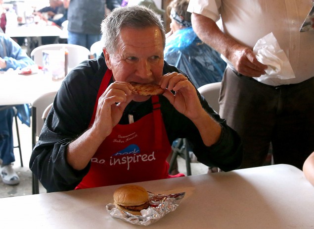 Republican presidential candidate and Ohio Gov. John Kasich eats a pork chop while visiting the Iowa Pork Producers Pork Tent during the Iowa State Fair on August 18, 2015 in Des Moines, Iowa. (Justin Sullivan/Getty Images)