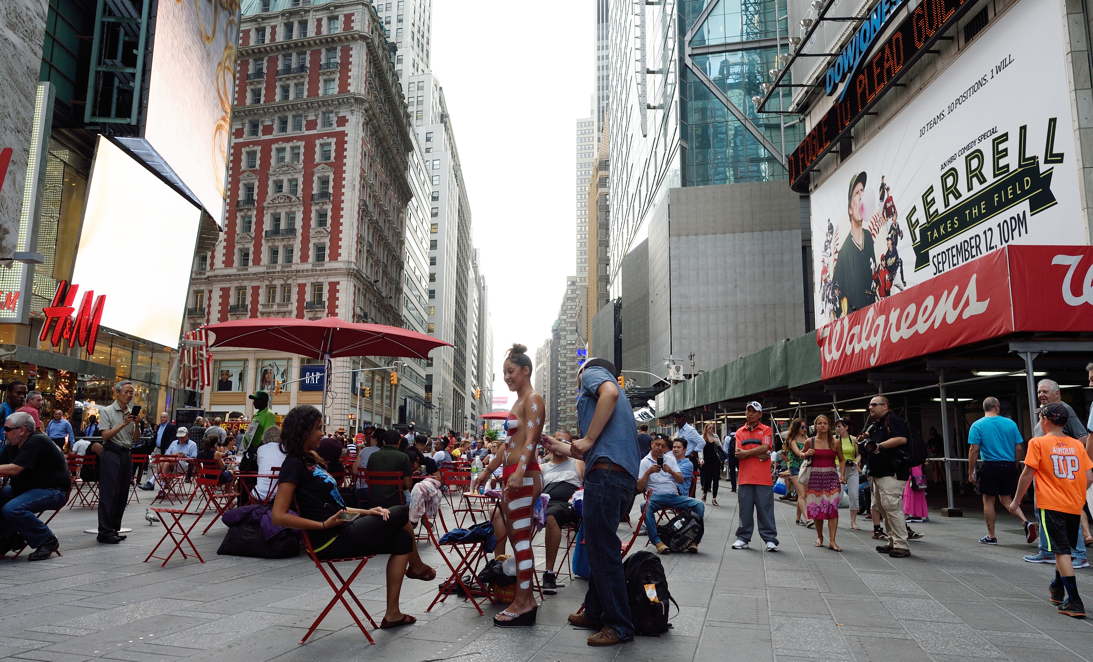 A young woman has her body painted in a Times Square pedestrian plaza. (Photo: DON EMMERT/AFP/Getty Images)