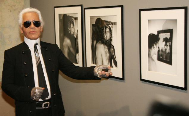 Mr. Lagerfeld poses with photos he took of Brad Kroenig. (Photo: OLIVER LANG/AFP/Getty Images)