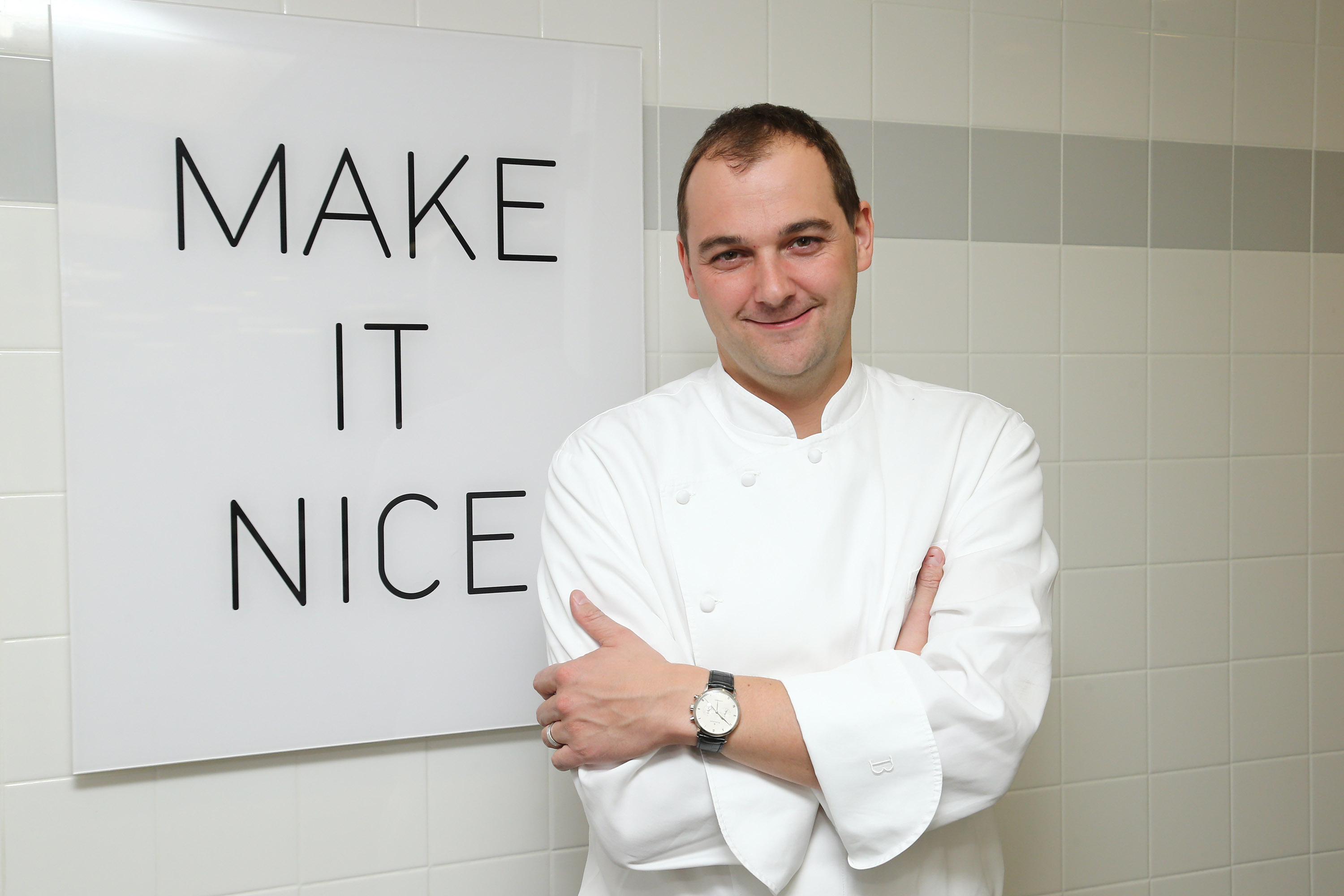 Chef Daniel Humm at Eleven Madison Park, standing next to a poster with the restaurant's slogan. (Photo: Getty Images)