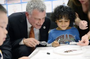 Mayor Bill de Blasio works with a student on a science project during a visit to a pre-K classroom in Manhattan. (GettyImages)