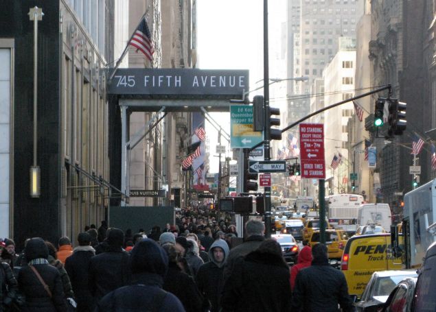 Crowds of bundled up pedestrians walk along 5th Avenue November 21, 2014 in New York. Cold temperatures and high winds made for a cold day of shopping. AFP PHOTO/Don Emmert (Photo credit should read DON EMMERT/AFP/Getty Images)