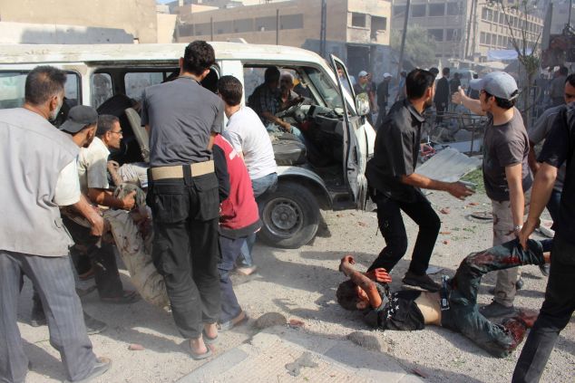 Residents and emergency personnel help the victims of Syrian government forces air strikes on a popular market in the rebel-held Eastern Ghouta town of Ain Tarma, east of the capital Damascus, on August 31, 2015. Eastern Ghouta has been under a government siege for nearly two years and comes under regular air attack. AFP PHOTO / MOHAMMED EYAD (Photo credit should read Mohammed Eyad/AFP/Getty Images)