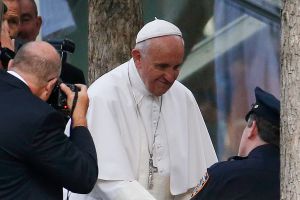 Pope Francis talks to a New York City police officer while visiting the South Pool at the World Trade Center. (Photo: Getty)