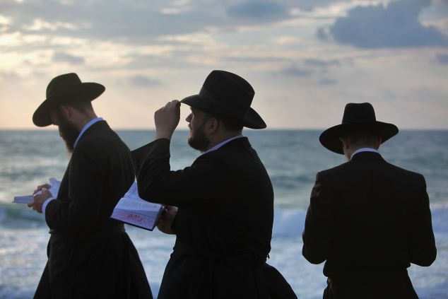 TEL AVIV, ISRAEL - SEPTEMBER 20: Ultra-Orthodox Jews perform the Tashlich prayer while facing the Mediterranean Sea at sunset of the second day of Rosh Hashanah, the Jewish new year, on September 20, 2009 in Tel Aviv, Israel. Tashlich, which means 'to cast away', is the practice by which Jews go to a flowing body of water and symbolically 'throw away' their sins during the days of repentance between Rosh Hashanah and the upcoming day of atonement, or Yom Kippur, the holiest day in the Jewish calendar. (Photo by David Silverman/Getty Images)