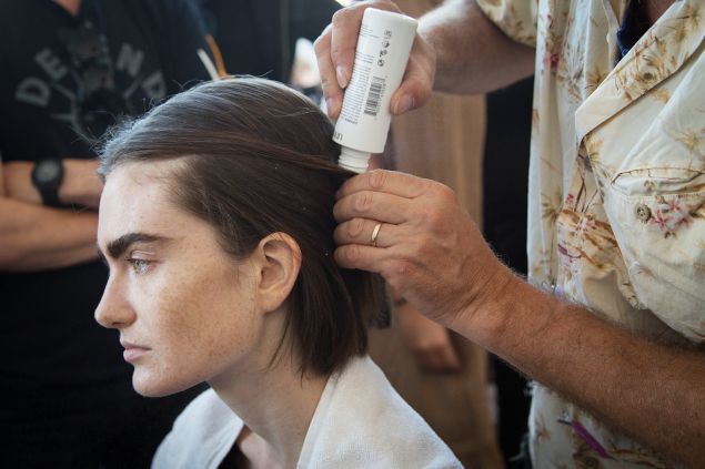 Mr. Ryan applies powder to a model's hair. (Photo: Observer/Kaitlyn Flannagan)