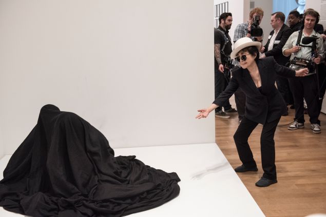 Yoko Ono interacting with people activating Bag Piece (1964), a participatory work in Yoko Ono: One Woman Show, 1960-1971, on view at MoMA, May 17 -September 7, 2015. (Photo: Courtesy of Ryan Muir © Yoko Ono)