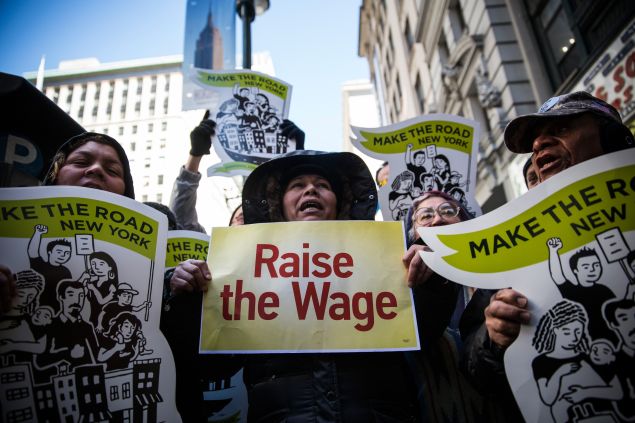 NEW YORK, NY - MARCH 18: Women hold banners during a protest for higher wages for fast food workers on March 18, 2014 in New York City. The protest, arranged by the group "Fast Food Forward" accused fast food corporations of corporate greed and withholding wages. (Photo by Andrew Burton/Getty Images)