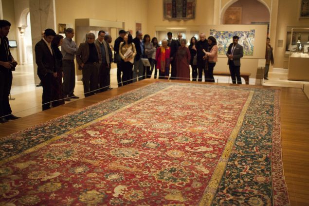 NEW YORK - DECEMBER 13: A guided tour group listens to a Metropolitan Museum of Art curator, 2nd right, December 13, 2011 as she explains one of the century's old Iranian carpets on view at the Nature of Islamic Art exhibit in New York City. The carpet, made in the 1550's, once decorated one of the residences of the Habsburg emperors. The Metropolitan Museum reopened and reinstalled the Islamic Art section in a 19,000 square foot wing after eight years of reconstruction. (Photo by Robert Nickelsberg/Getty Images)