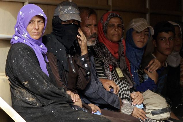 Syrian refugees sit in the back of a Jordanian army truck. (Photo: AFP PHOTO / KHALIL MAZRAAWI (Photo credit should read KHALIL MAZRAAWI/AFP/Getty Images)