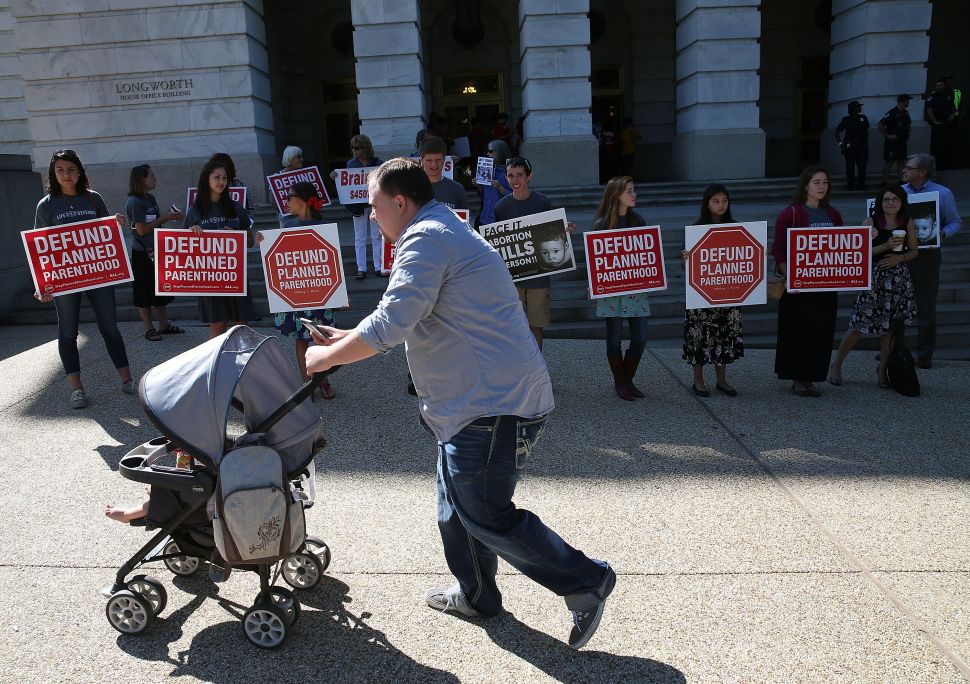 WASHINGTON, DC - SEPTEMBER 16: Protesters hold signs protesting Planned Parenthood in front of the Longworth House Office Building on Capitol Hill September 16, 2015 in Washington, DC. Rev. Patrick Mahoney of the Christian Defense Coalition urged the Republican leadership not to give taxpayer funding to Planned Parenthood. (Photo by Mark Wilson/Getty Images)