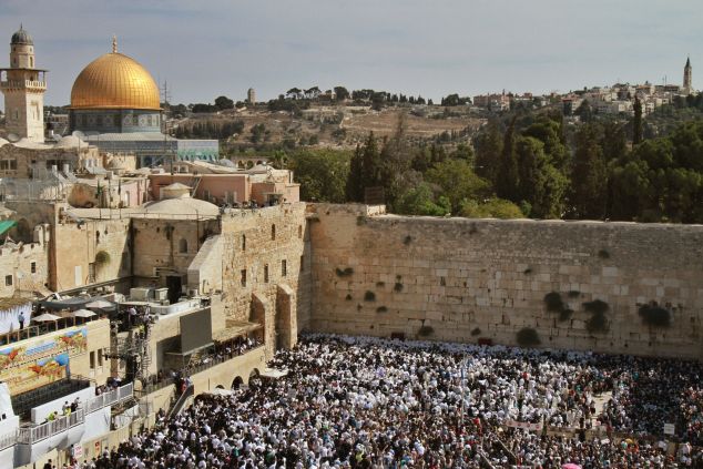 Jewish worshippers draped in prayer shawls perform the annual Cohanim prayer (priest's blessing) during Sukkot, or the feast of the Tabernacles, holiday at the Western Wall in the old city of Jerusalem on September 30, 2015. Tens of thousands of Jews make the week-long pilgrimage to Jerusalem during Sukkot, which commemorates the desert wanderings of the Israelites after their exodus from Egypt. AFP PHOTO / GIL COHEN-MAGEN (Photo credit should read GIL COHEN MAGEN/AFP/Getty Images)