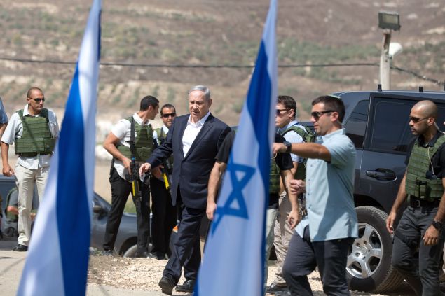 Israeli Prime Minister Benjamin Netanyahu (C) walks at the Horon army camp near the Palestinian city of Nablus in the Israeli-occupied West Bank, on October 6, 2015. Israel demolished the homes of two Palestinians behind attacks and sealed off a room in another, the army said, after Netanyahu pledged an iron fist against mounting unrest. AFP PHOTO / MENAHEM KAHANA (Photo credit should read MENAHEM KAHANA/AFP/Getty Images)