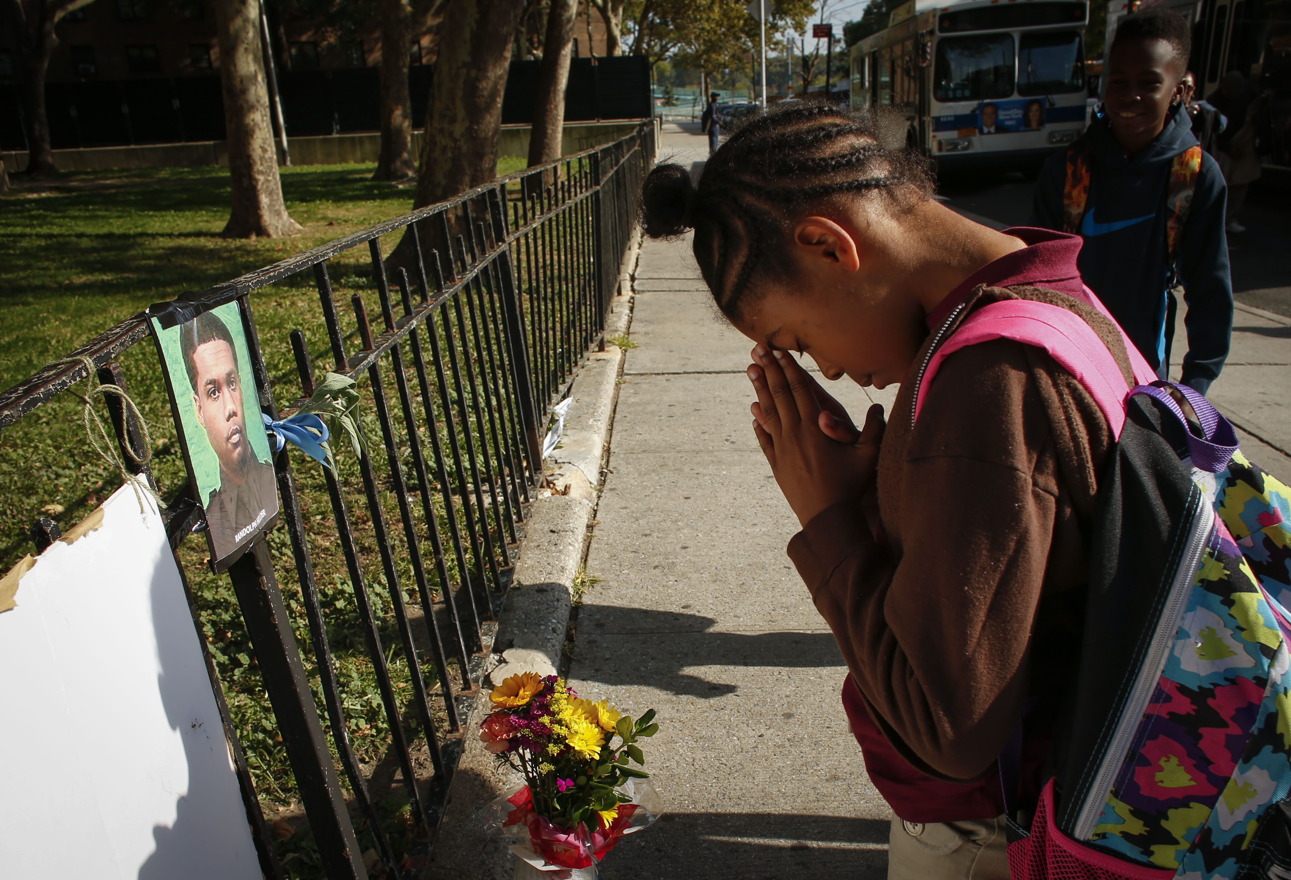A girl prays at a makeshift memorial for police officer Randolph Holder outside the Wagner Houses community center on October 21, 2015 in New York City. (Photo by Kena Betancur/Getty Images)