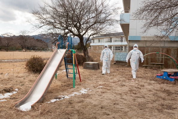NAMIE, FUKUSHIMA PREFECTURE - FEBRUARY 27: Police sergeant Yabuki Koshin and Constable Kanno Tomoyasu walk the grounds of Obori Kindergarten whilst on patrol within the 20km exclusion zone around Fukushima Daiichi nuclear plant, on February 27, 2012 in Namie, Fukushima prefecture, Japan. Police patrol the evacuated 20km exclusion zone, which is in force around the stricken Fukushima Daiichi nuclear plant, and which encompasses six towns and two villages, looking for any signs of burglaries or crime in the now uninhabited zone. The exclusion zone used to be home to approximately 73,000 people but all have been evacuated by the government and are now restricted from returning home due to high levels of radioactive contamination from the explosions at the TEPCO owned Fukushima Daiichi nuclear plant following the earthquake and tsunami of March 11 2011. (Photo by Jeremy Sutton-Hibbert/Getty Images)