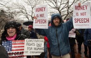 Demonstrators march in the snow through Lafayette Park, outside the White House, to the US Chamber of Commerce during a rally against the Supreme Court's decision five years ago in favor of Citizens United, which allows private citizens and corporations to make unlimited donations for political campaigns, in Washington,DC on January 21, 2015. AFP PHOTO/NICHOLAS KAMM (Photo credit should read NICHOLAS KAMM/AFP/Getty Images)