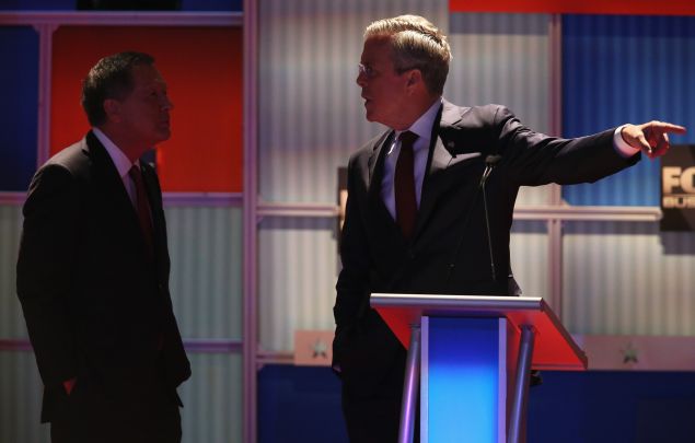 MILWAUKEE, WI - NOVEMBER 10: Republican presidential candidate Jeb Bush speaks with Ohio Gov. John Kasich during a commercial break at the Republican Presidential Debate sponsored by Fox Business and the Wall Street Journal at the Milwaukee Theatre November 10, 2015 in Milwaukee, Wisconsin. The fourth Republican debate is held in two parts, one main debate for the top eight candidates, and another for four other candidates lower in the current polls. (Photo by Scott Olson/Getty Images)