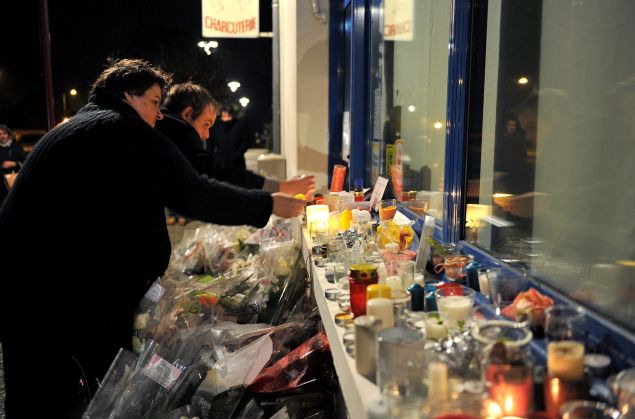 People light candles outside the Petard Butcher Shop in Chailles, near Blois, central France, on November 17, 2015, to pay tribute to Anna and Marion Petard-Lieffrig, victims of the attacks claimed by Islamic State (IS) on November 13 in Paris. Anna Petard, 26 years old, and her sister Marion, 30 years old, were killed in the restaurant "Le petit Cambodge". AFP PHOTO / GUILLAUME SOUVANT (Photo credit should read GUILLAUME SOUVANT/AFP/Getty Images)