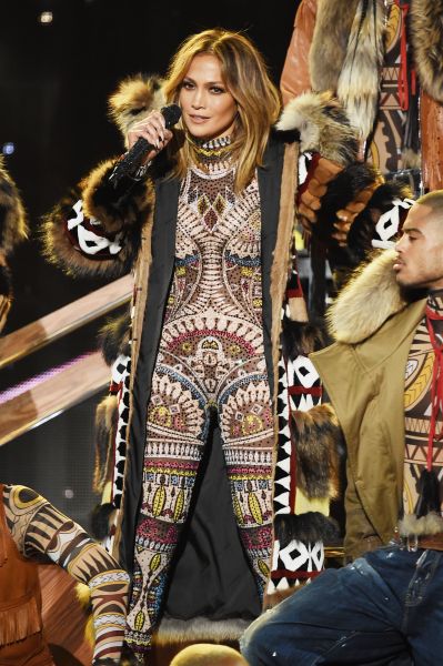 Jennifer Lopez gets the show started in a custom DSquared2 jumpsuit and coat (Photo: Getty Images).