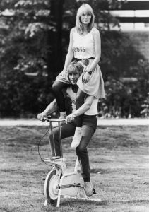 English racing driver James Hunt (1947 - 1993) poses on an exercise bicycle with ex-girlfriend Jane Birbeck on his shoulders to publicise the opening of their health club 'Bodys', 10th May 1982. (Photo by Gary Stone/Central Press/Hulton Archive/Getty Images)