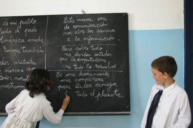 TO GO WITH AFP STORY A schoolgirl writes old-fashion with chalk on a blackboard while in class 07 December, 2007 in Villa Cardal, 80km from Montevideo. The sentences written on the board aim to explain basic concepts and advantages of the use of computers in education: "This new communication era opens the way to information", "But above all, don't forget that computers can't solve it all" and "It is a tool, a companion to make friends around the planet". The small 2,000 inhabitants village of Villa Cardal was chosen by its peculiar characteristics to host the first stage of the "Ceibal" (A native forest of 'ceibo' trees) project, consisting in assigning a specially designed laptop to each schoolboy to be used as a learning tool and to connect the young students of even remote places to the rest of the world. AFP PHOTO PANTA ASTIAZARAN (Photo credit should read PANTA ASTIAZARAN/AFP/Getty Images)