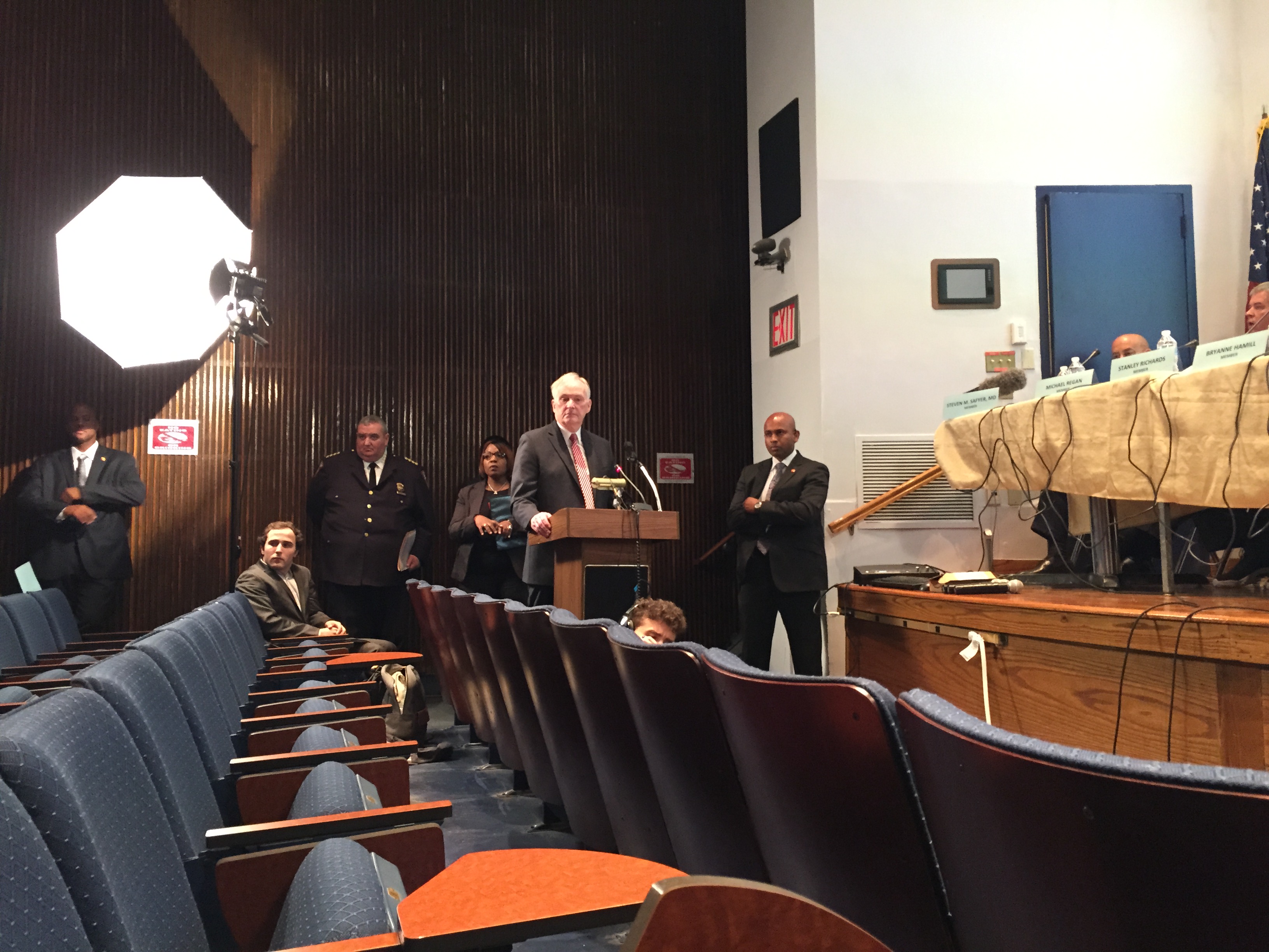 Correction Commissioner Joseph Ponte stands alone at a podium as protesters interrupt him. (Photo: Jillian Jorgensen for Observer)