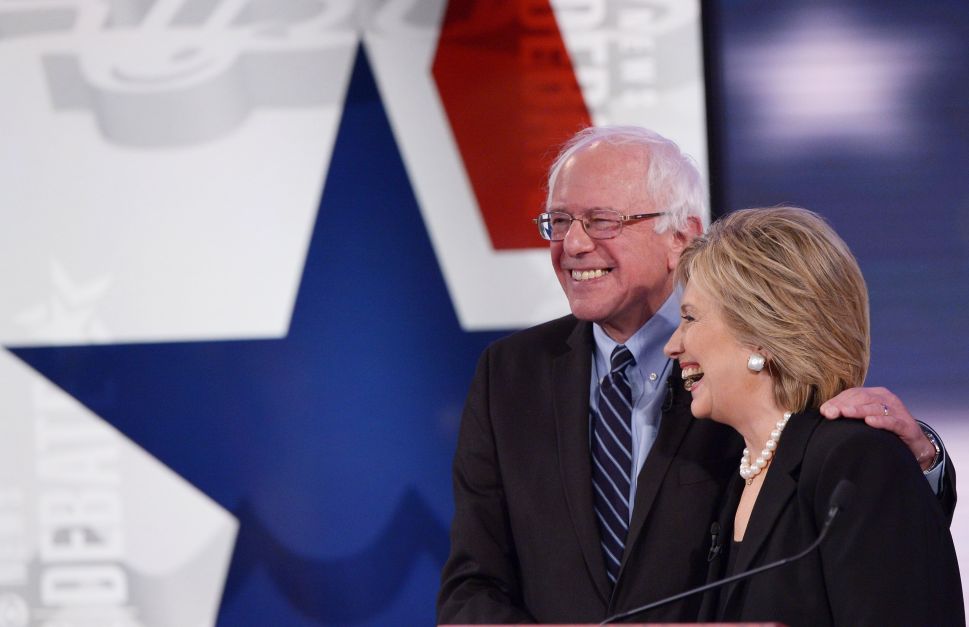 Democratic Presidential hopefuls Hillary Clinton and Bernie Sanders hug after the second Democratic presidential primary debate in Iowa. (Photo: MANDEL NGAN/AFP/Getty Images)