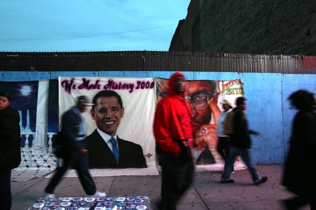 NEW YORK - NOVEMBER 04: Residents of the historically African-American neighborhood of Harlem walk by images of human rights activist Malcolm X and Democratic presidential nominee U.S. Sen. Barack Obama (D-IL) on Election Day on November 4, 2008 in New York City. After months of sometimes heated campaigning between Republican presidential nominee Sen. John McCain (R-AZ) and Obama, Americans are finally voting today for the president of the United States. (Photo by Spencer Platt/Getty Images)