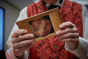 Terry Borton holding a slide used in his Magic Lantern, dating from the 1890's. (Harry Zernike for the Observer.)