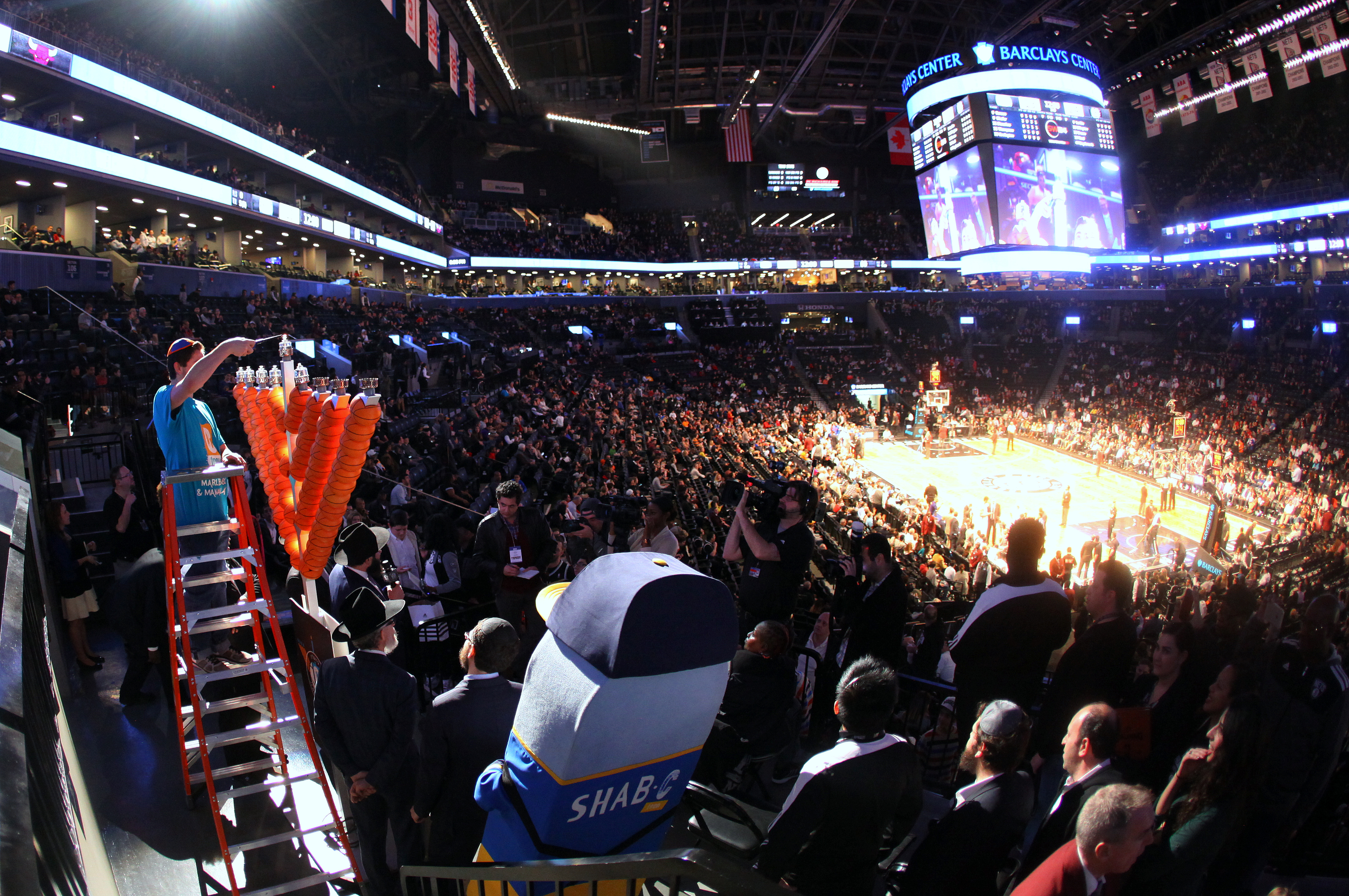 Mike Goldberg lights a basketball menorah as part of Jewish Heritage Night at the Barclays Center. (Photo: Bentzi Sasson / CTeen.com)