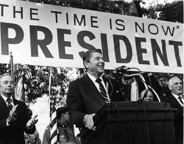American politician Ronald Reagan smiles as he speaks on his presidential campaign in front of a large banner, 1979. Pennsylvania governor William Scranton (L) applauds. (Photo by Hulton Archive/Getty Images)
