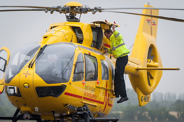 CAMBRIDGE , UNITED KINGDOM - JULY 13: Prince William, The Duke of Cambridge performs checks on his helicopter as he begins his new job with the East Anglian Air Ambulance (EAAA) at Cambridge Airport on July 13, 2015 in Cambridge, England. The former RAF search and rescue helicopter pilot will work as a co-pilot transporting patients to hospital from emergencies ranging from road accidents to heart attacks. (Photo by Stefan Rousseau WPA - Pool/Getty Images)