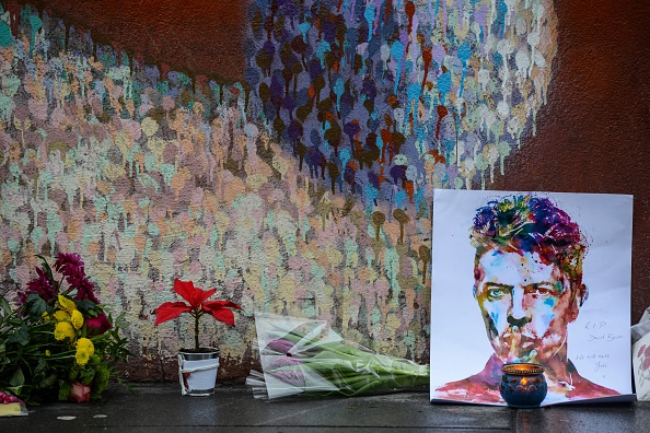Floral tributes are left beneath a mural of British singer David Bowie, following the announcement of Bowie's death, in Brixton, south London, on January 11, 2016. British music icon David Bowie died of cancer at the age of 69, drawing an outpouring of tributes for the innovative star famed for groundbreaking hits like "Ziggy Stardust" and his theatrical shape-shifting style. AFP PHOTO / CHRIS RATCLIFFE / AFP / CHRIS RATCLIFFE (Photo credit should read CHRIS RATCLIFFE/AFP/Getty Images)