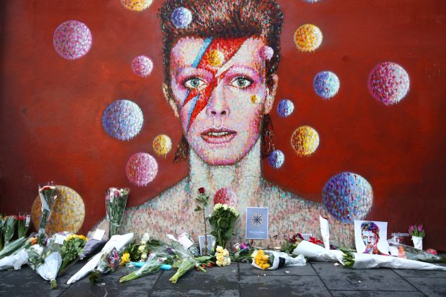 Flowers are laid beneath a mural of David Bowie. (Photo by Carl Court/Getty Images)