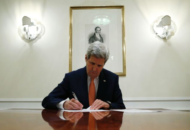 US Secretary of State John Kerry signs a series of documents during the E3/EU+3 and Iran talks in Vienna on January 16, 2016. The historic nuclear accord between Iran and major powers entered into force as the UN confirmed that Tehran has shrunk its atomic programme and as painful sanctions were lifted on the Islamic republic. / AFP / POOL / KEVIN LAMARQUE (Photo credit should read KEVIN LAMARQUE/AFP/Getty Images)